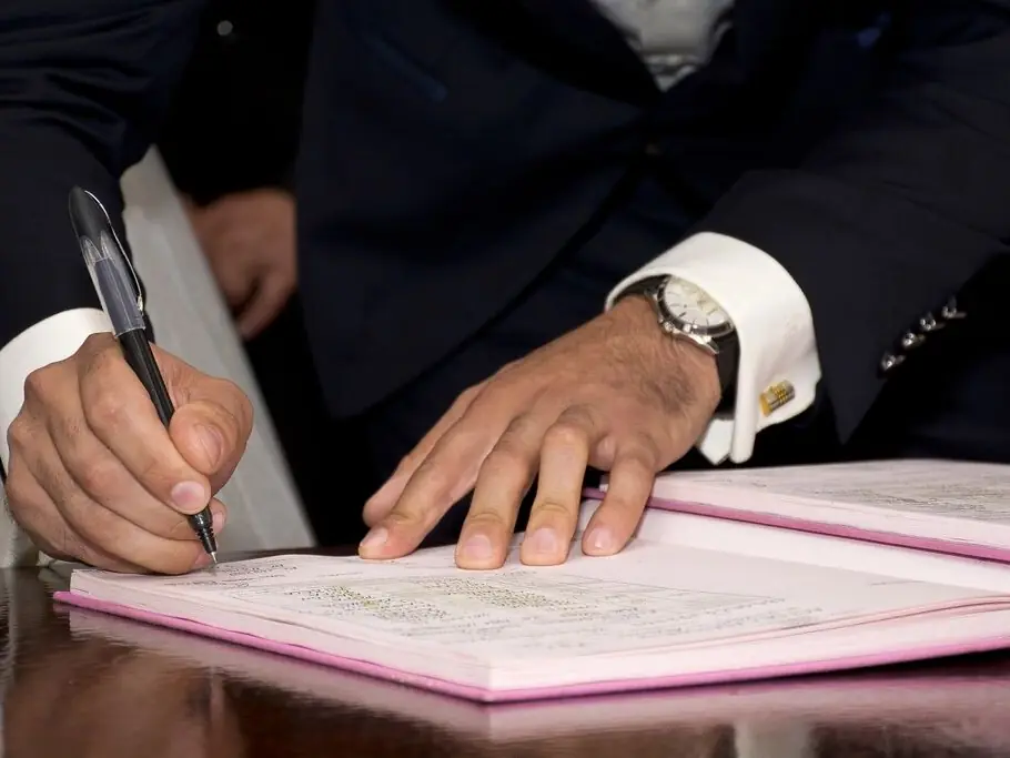 Firma di un documento al tavolo dello studio