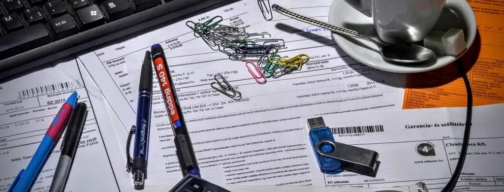 Scrivania con documenti contabili, calcolatrice e caffè